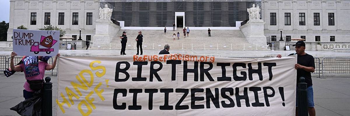 People hold signs reading, "Hands off birthright citizenship" outside US Supreme Court.