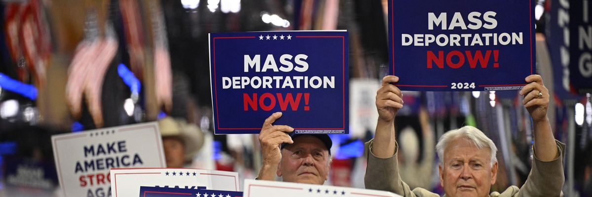 People hold signs reading, "Mass deportations now," at RNC.
