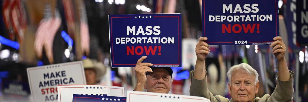 People hold signs reading, "Mass deportations now," at RNC.
