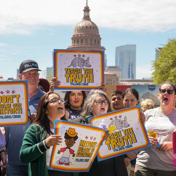 People hold signs reading "tech the truth" and "don't erase our history" during a protest in Austin