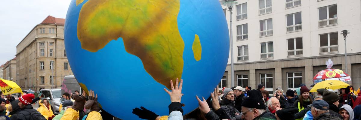People hold up a globe.