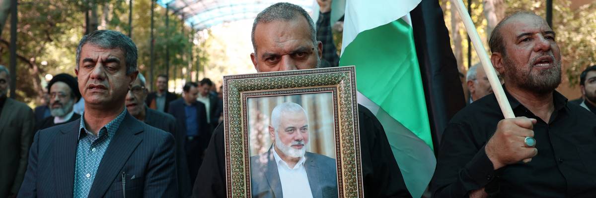 People hold up a portrait of assassinated Hamas political chief Ismail Haniyeh