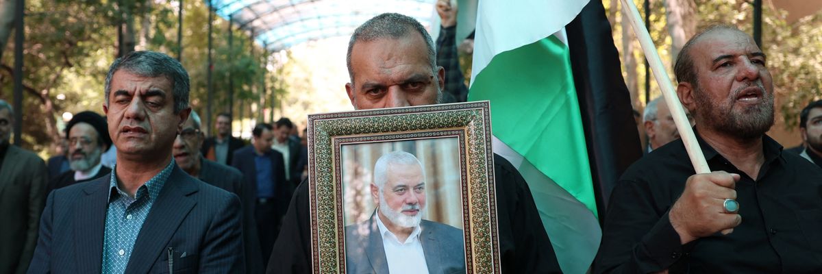 People hold up a portrait of assassinated Hamas political chief Ismail Haniyeh