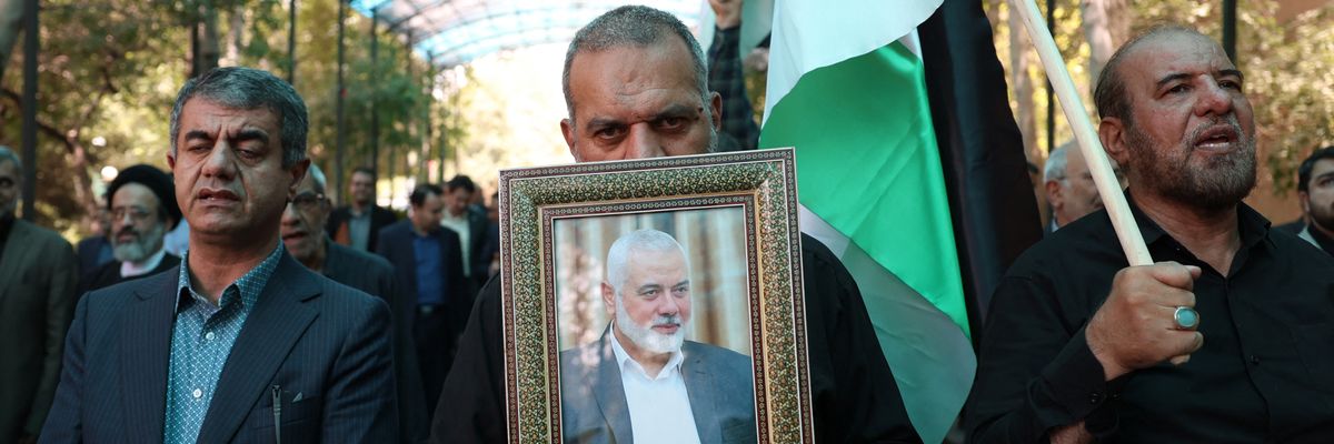 People hold up a portrait of assassinated Hamas political chief Ismail Haniyeh
