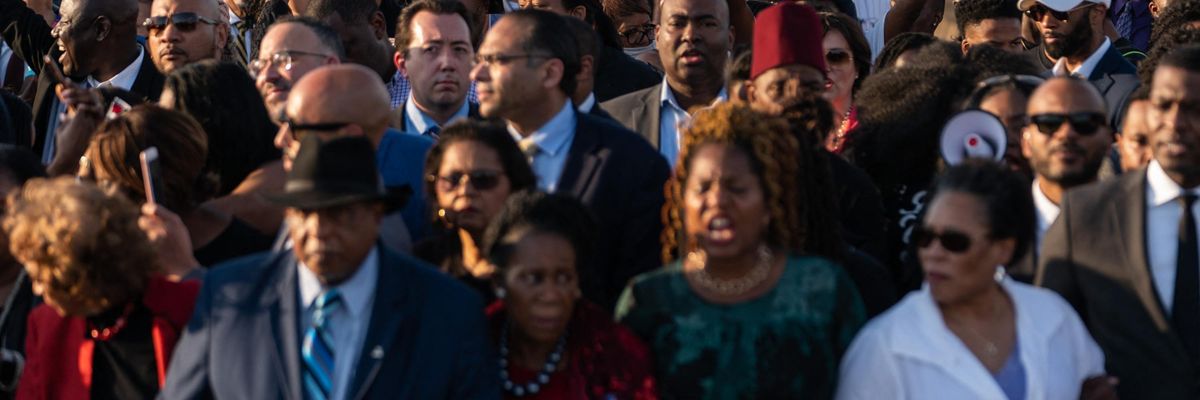 People hold up 'Protect Our Vote' signs as they march across the Edmund Pettus Bridge in commemoration of the 57th anniversary of 'Bloody Sunday' in Selma, Alabama on March 6, 2022