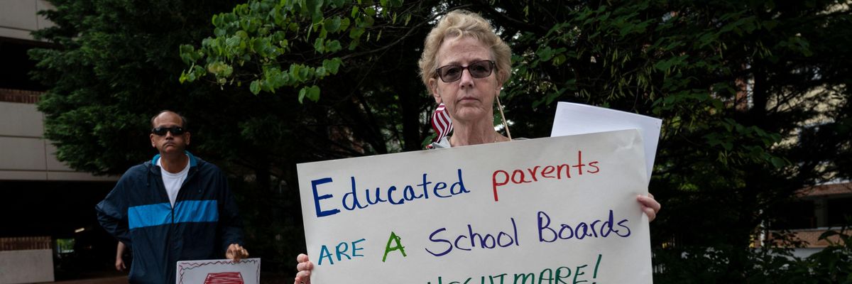 People hold up signs during a rally against "Critical Race Theory" (CRT) being taught in schools at the Loudoun County Government Center in Leesburg, Virginia on June 12, 2021. (Photo: Andrew Caballero-Reynolds/AFP via Getty Images)