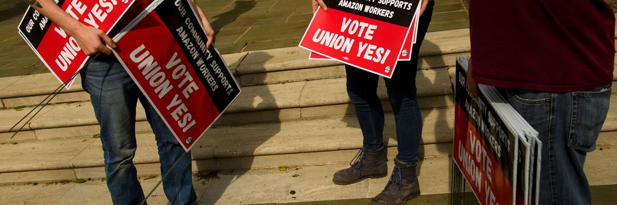 People hold "Vote Union Yes!" signs