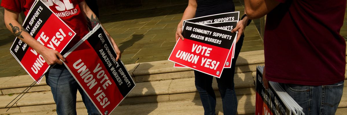 People hold "Vote Union Yes!" signs 