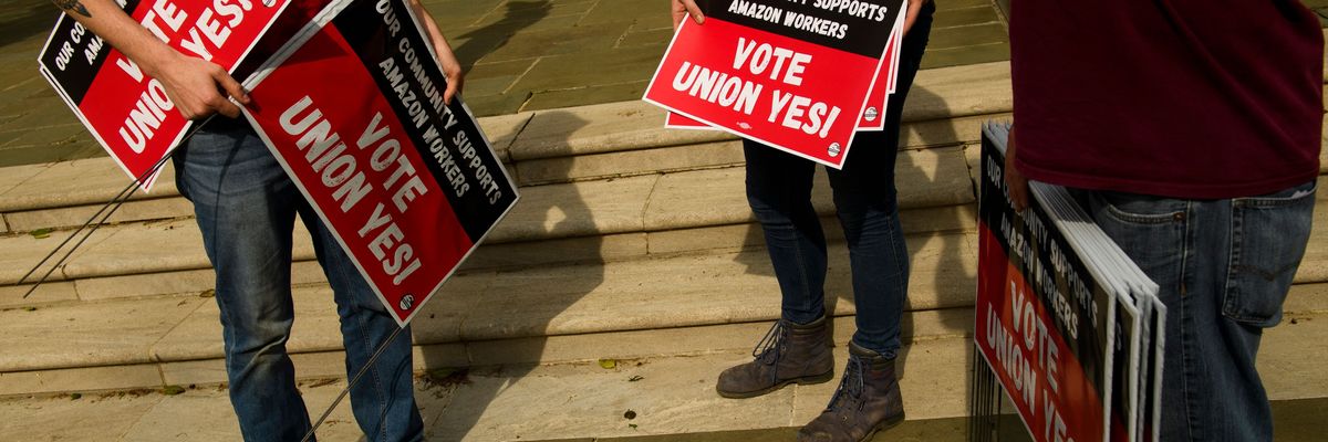 People hold "Vote Union Yes!" signs 