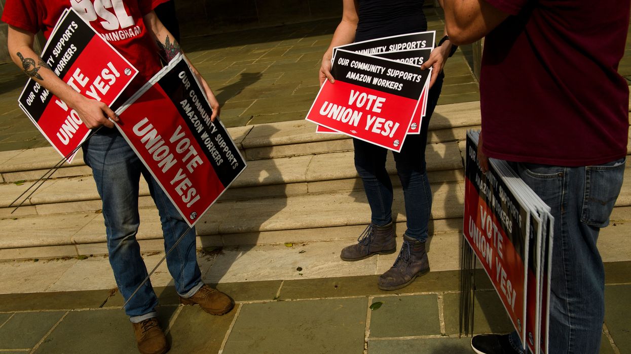 People hold "Vote Union Yes!" signs