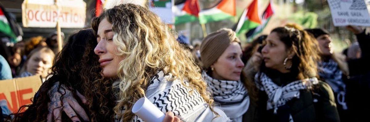 People hug outside the ICJ after ruling on January 26, 2024