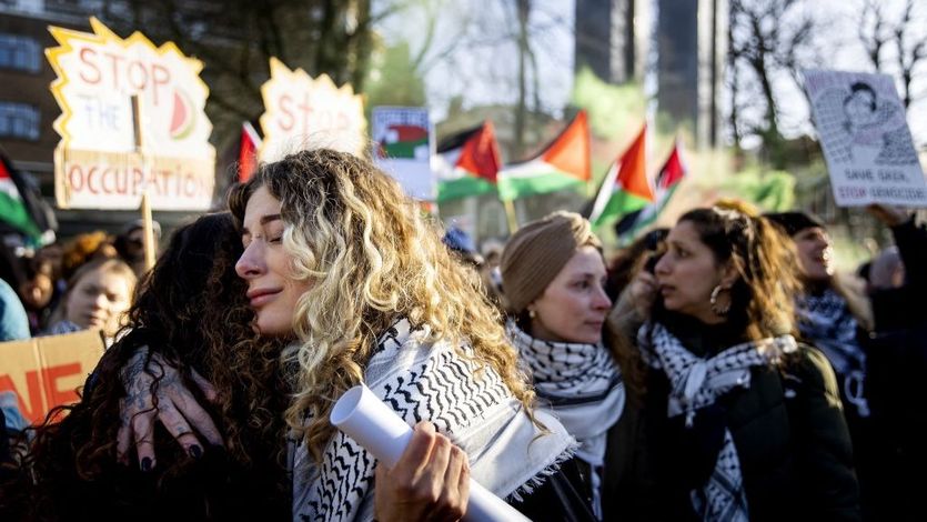 People hug outside the ICJ after ruling on January 26, 2024