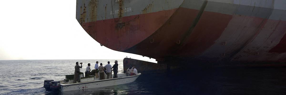 People in a small boat approach the FSO Safer oil tanker