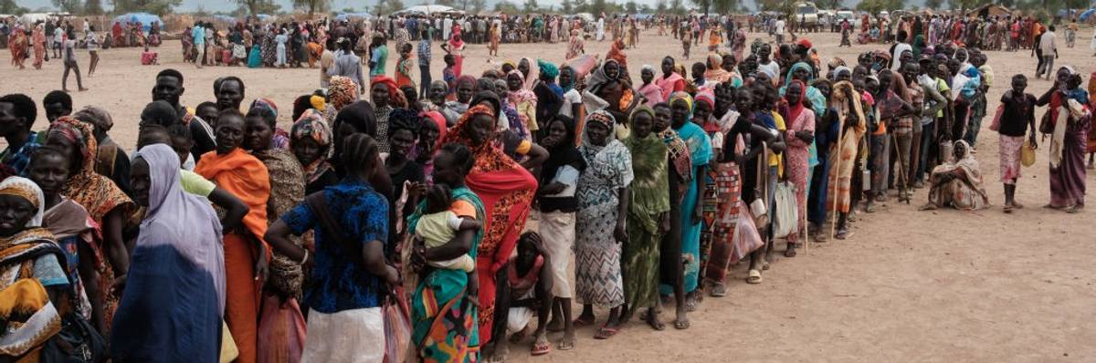 People in Sudan line up to register for food aid