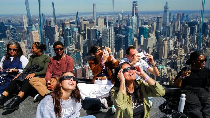 People in watch the solar eclipse in glasses.