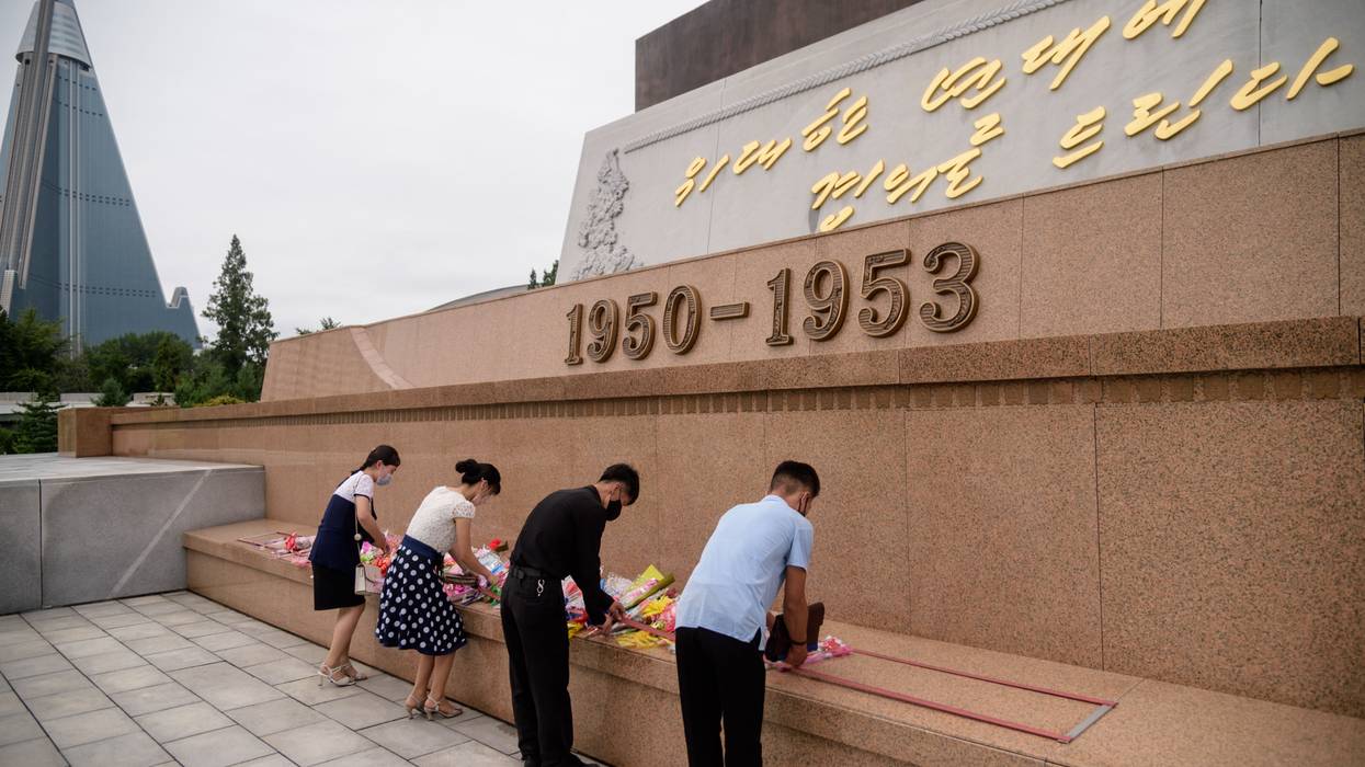 People lay flowers at a North Korean war memorial.