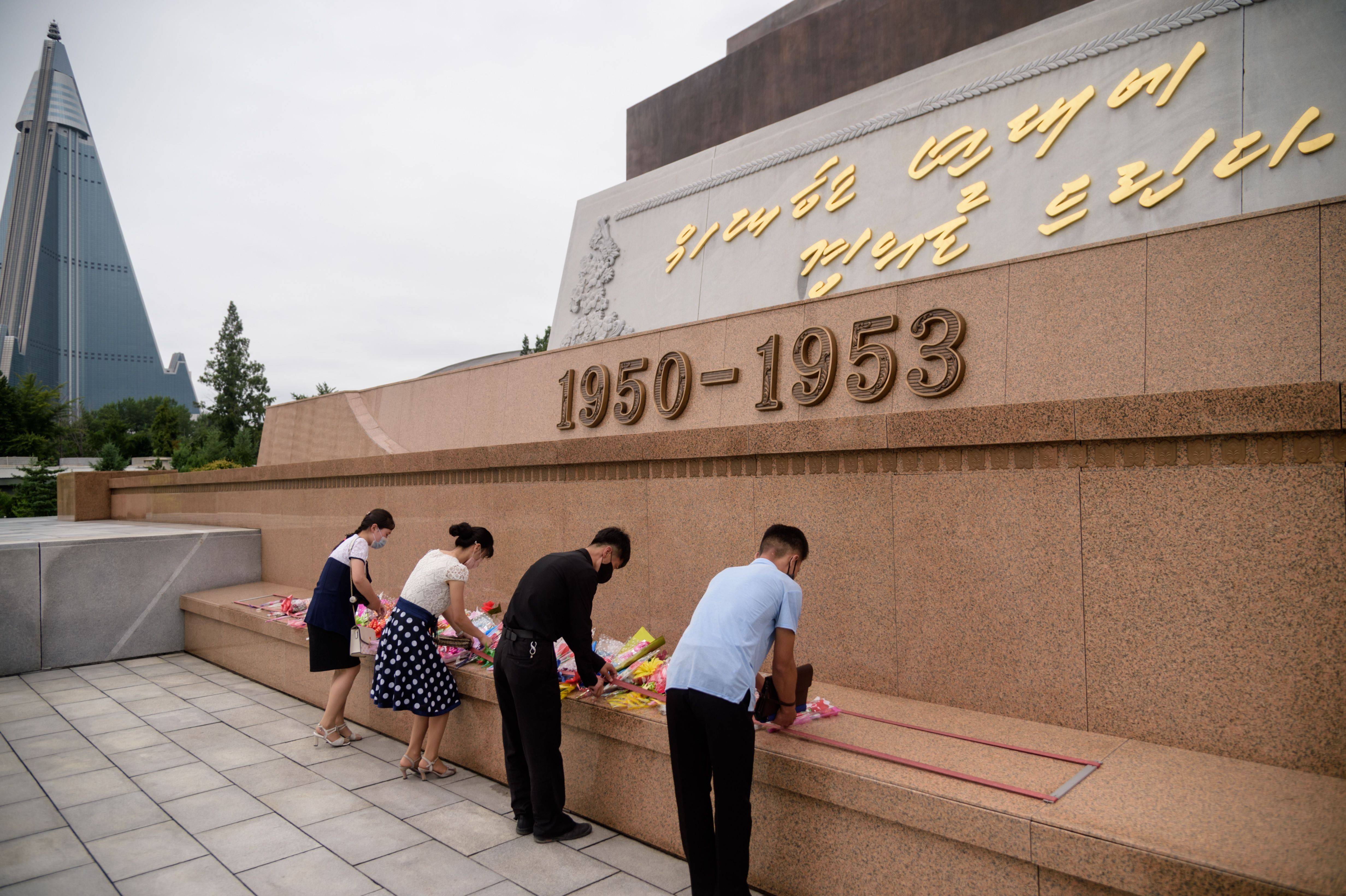 People lay flowers at a North Korean war memorial.