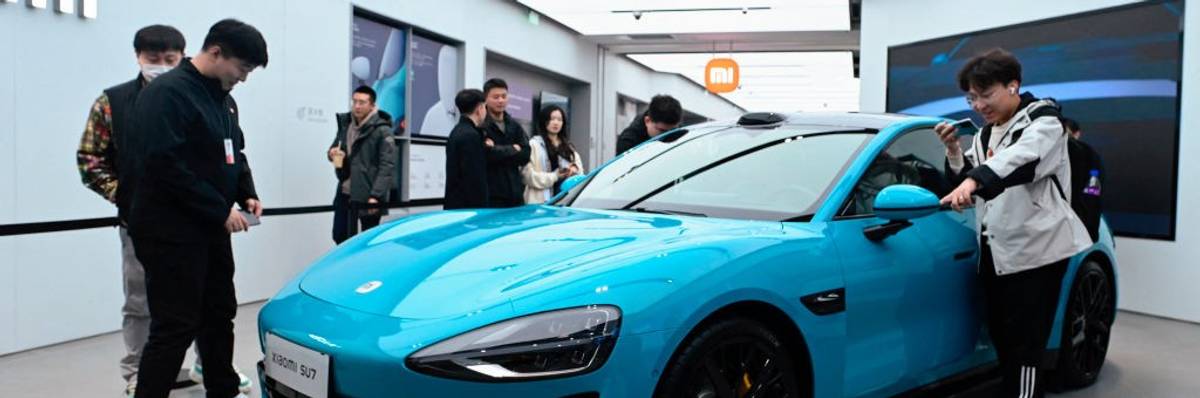 People look at a Xiaomi SU7 electric car