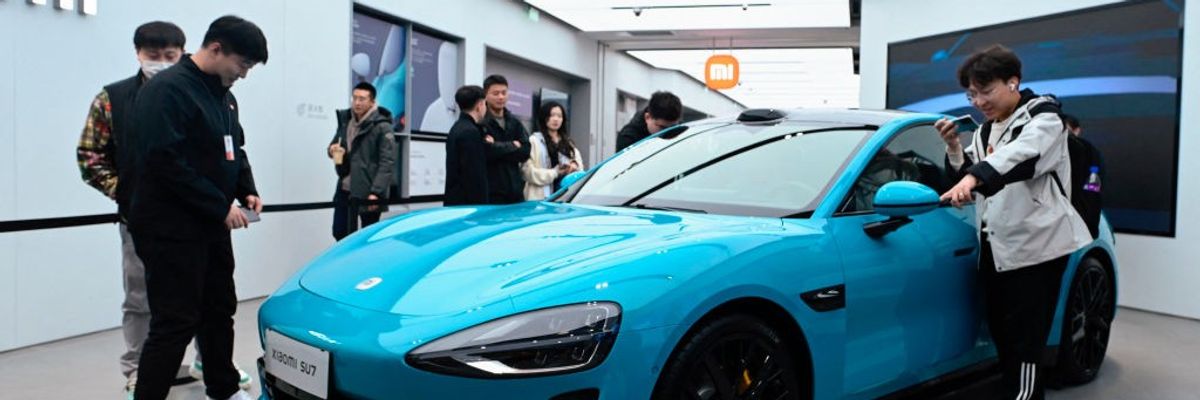 People look at a Xiaomi SU7 electric car