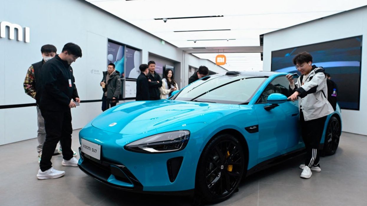 People look at a Xiaomi SU7 electric car