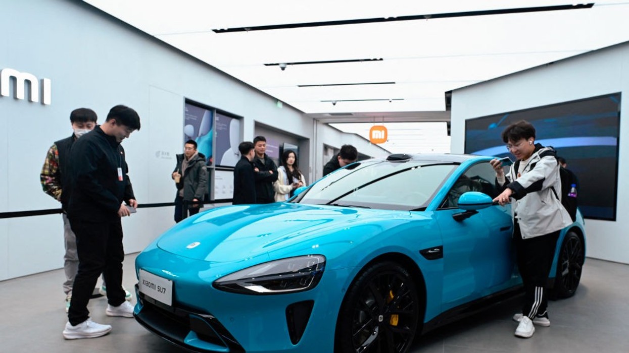 People look at a Xiaomi SU7 electric car