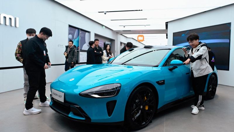 People look at a Xiaomi SU7 electric car