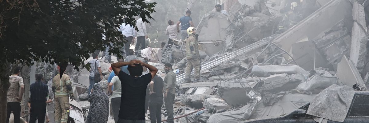 People look at damage in Tehran after Israeli air strikes.