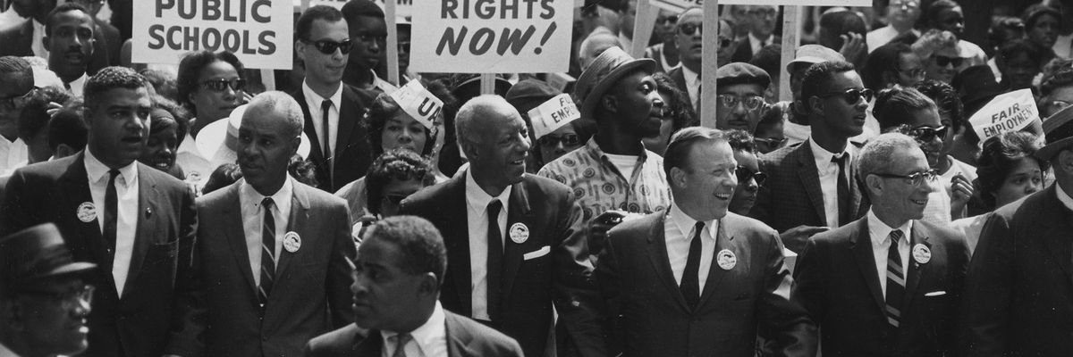 People march with signs in the 1963 March on Washington. 