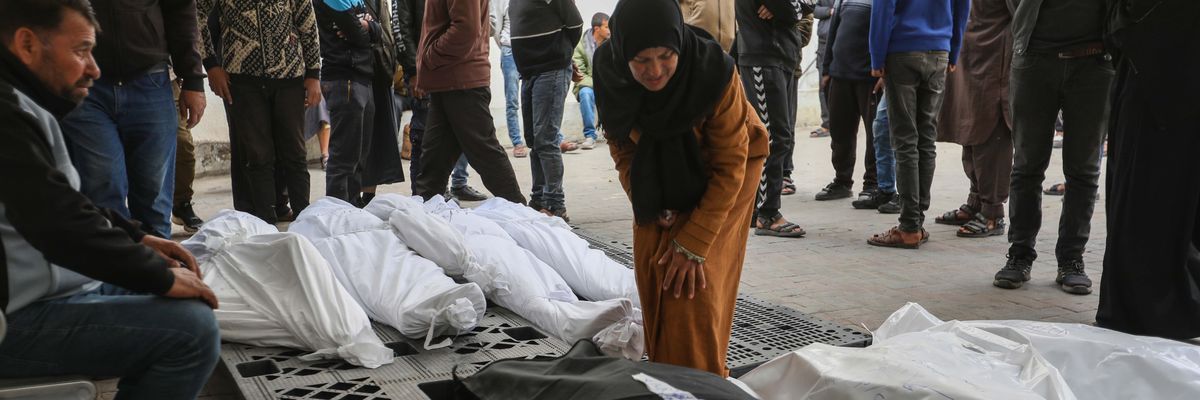 People mourn as they receive the dead bodies of victims of an Israeli strike