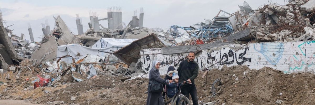 People move through a destroyed neighborhood of the Jabalia refugee camp in the northern Gaza Strip