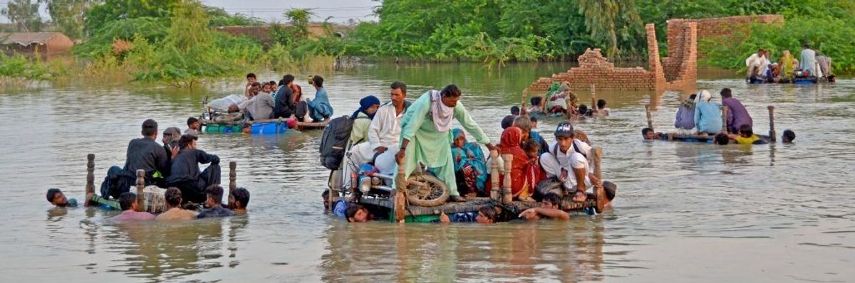 People on makeshift floats in the floodwaters of Pakistan