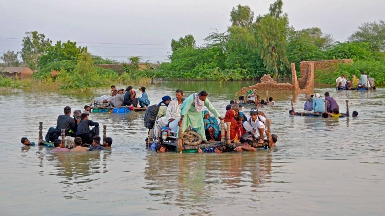 People on makeshift floats in the floodwaters of Pakistan