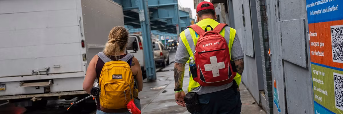 People part of an outreach team walk during a clearing of a homeless encampment