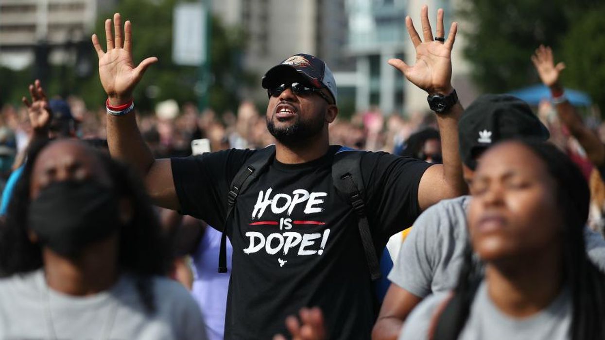 People pray together during a Juneteenth event
