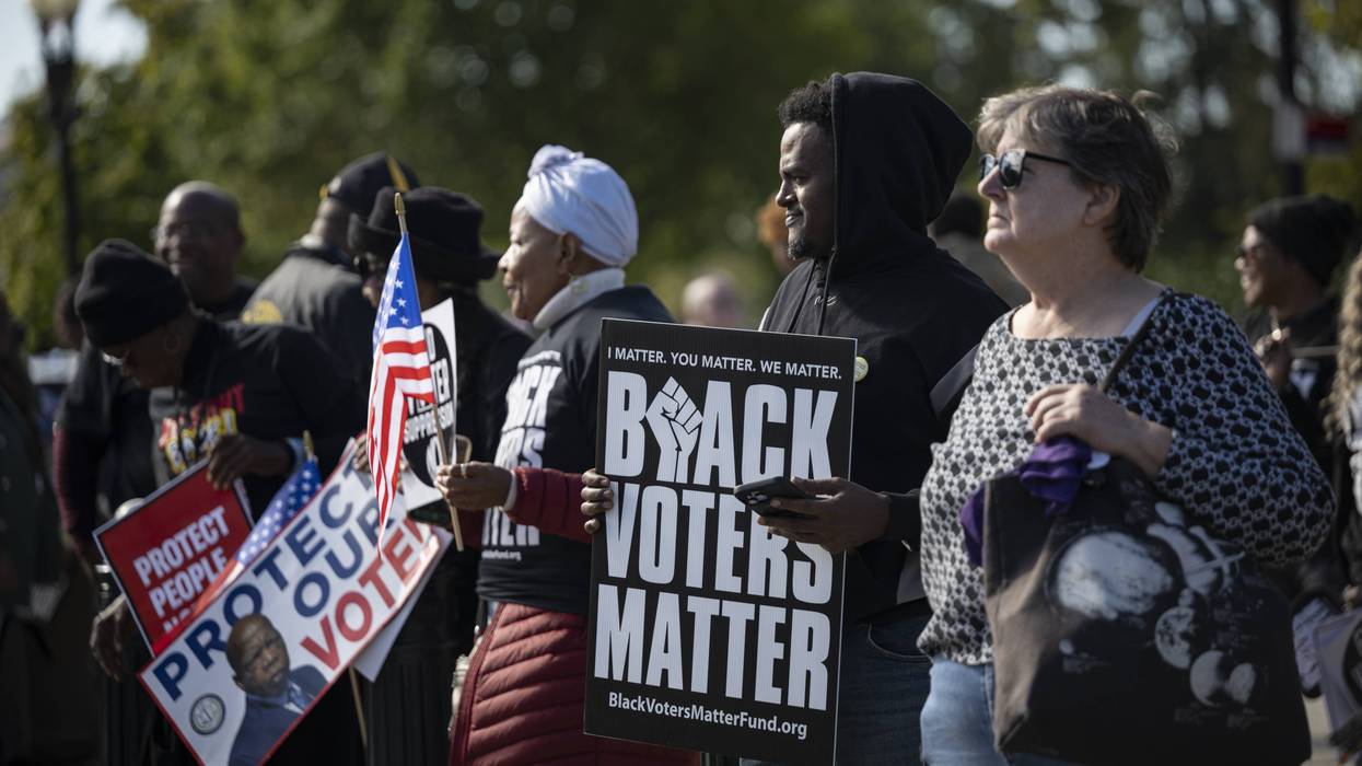 People protest for voting rights; one holds a sign reading "Black voters matter"