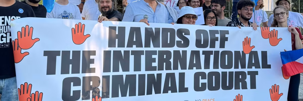 People protest with a sign reading "Hands off the International Criminal Court"
