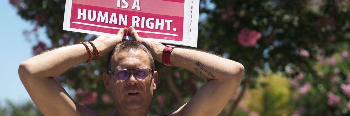 People rally in favor of single-payer healthcare for all Californians outside the office of California Assembly Speaker Anthony Rendon, June 27, 2017 in South Gate, California.