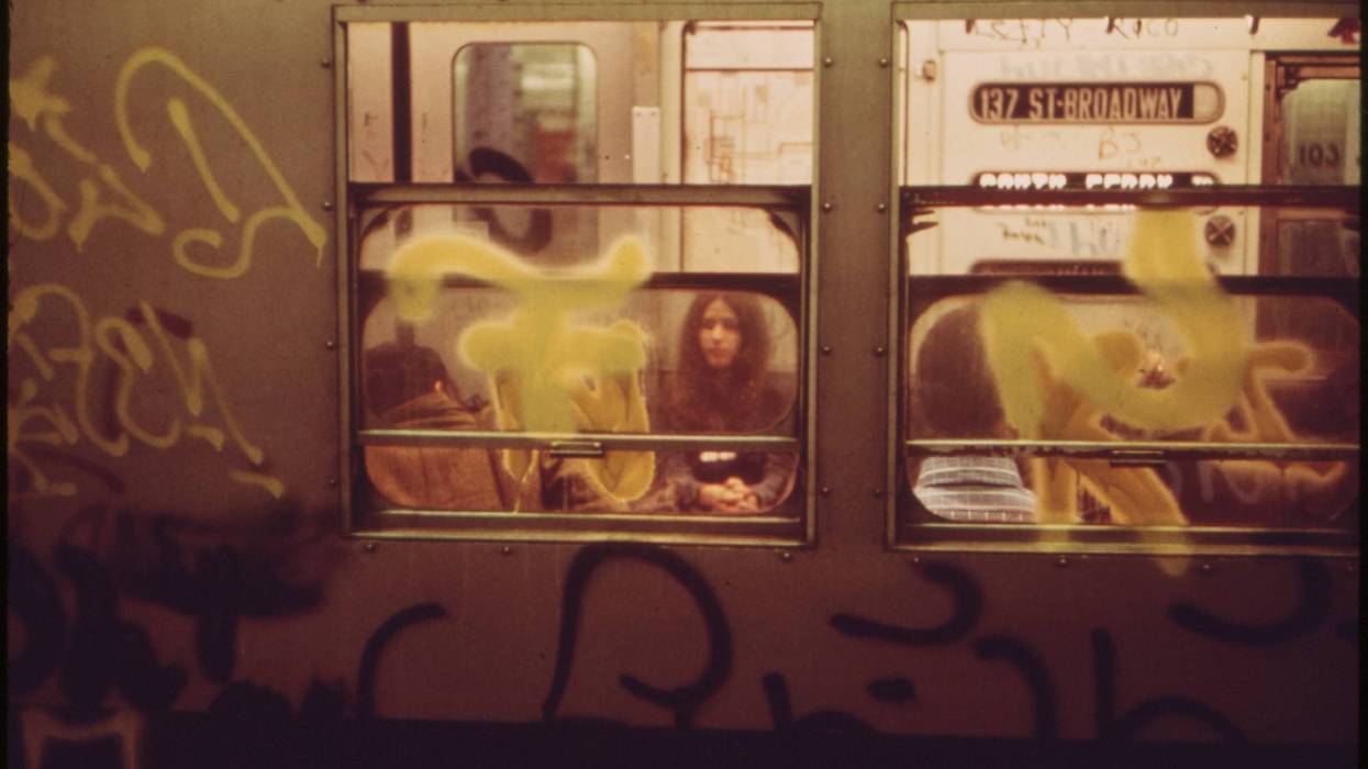 People seen through gritty subway window.