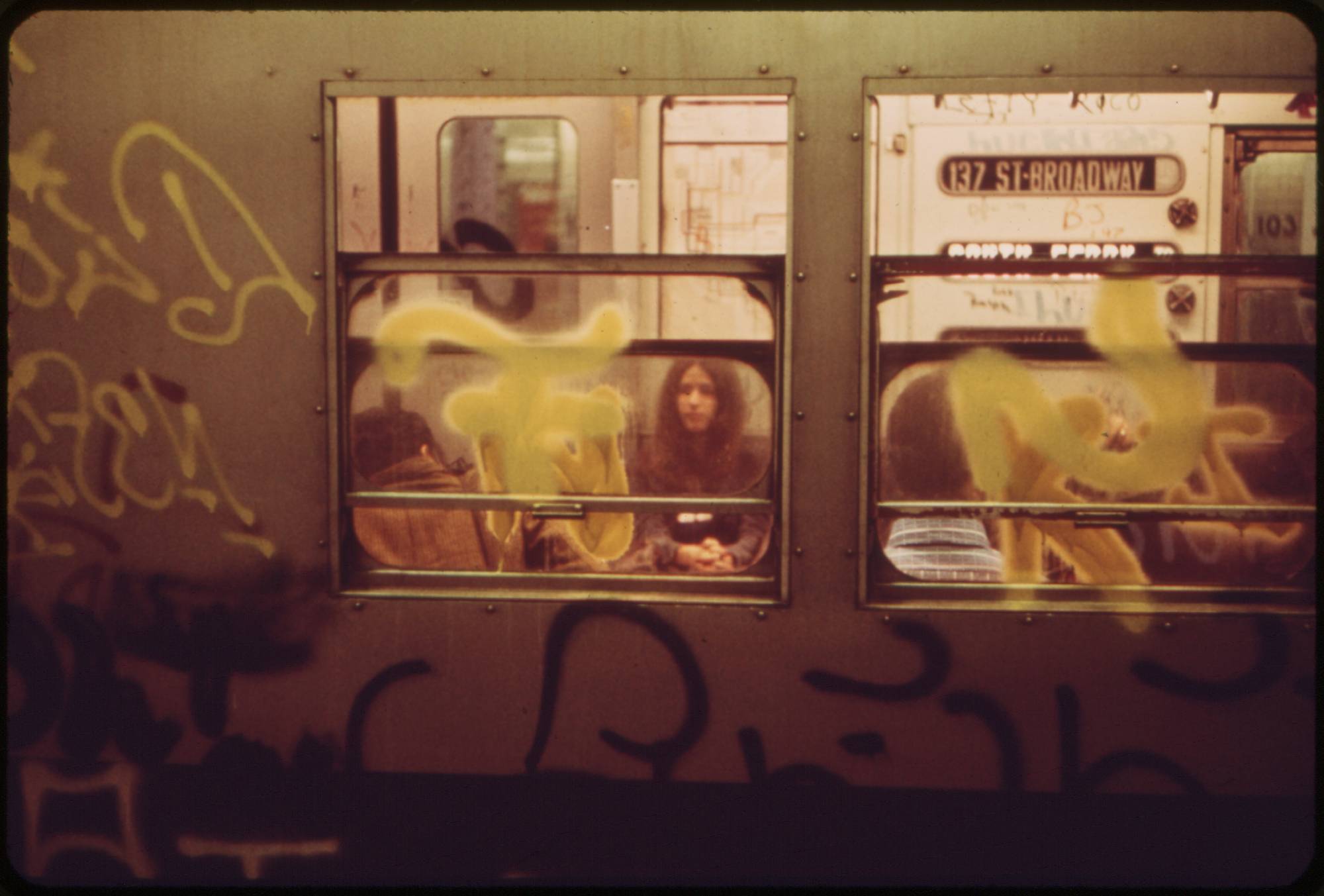 People seen through gritty subway window.
