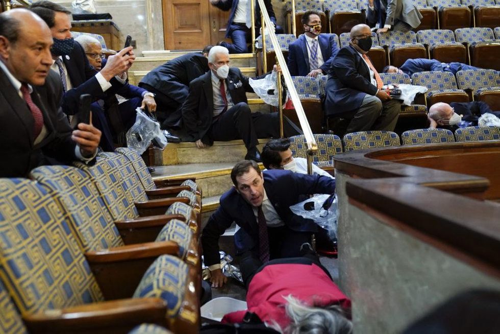 People shelter in the House gallery as protesters try to break into the House Chamber at the U.S. Capitol on Wednesday, Jan. 6, 2021, in Washington. (Andrew Harnik/AP)