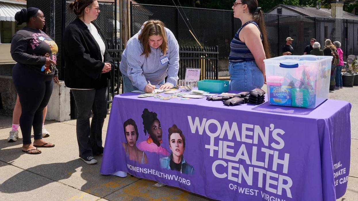 People sign up at a Women's Health Center of West Virginia table.