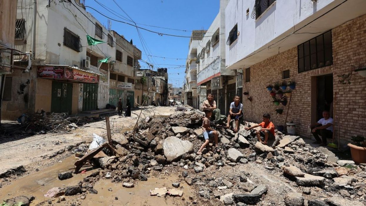 People sit in rubble after the Israeli raid of Jenin.