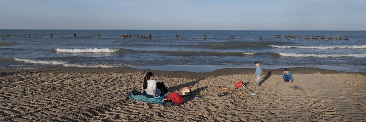 People sit on the beach along Lake Michigan on February 26, 2024 in Chicago, Illinois.