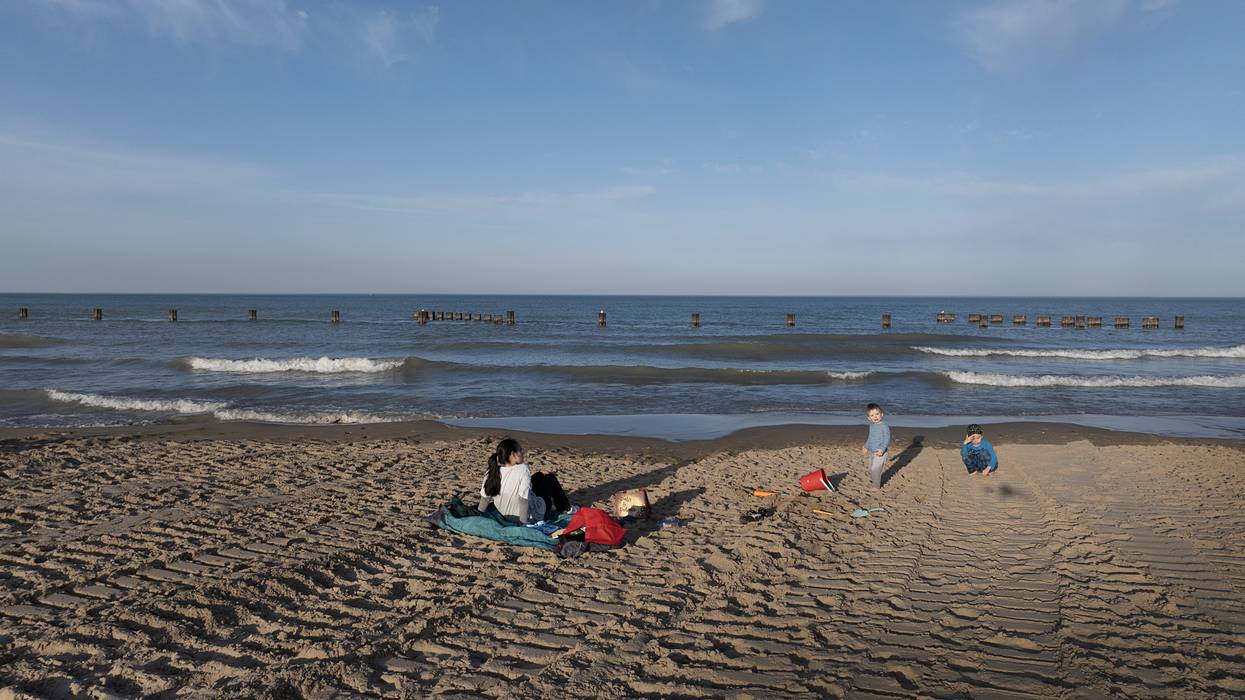 People sit on the beach along Lake Michigan on February 26, 2024 in Chicago, Illinois.