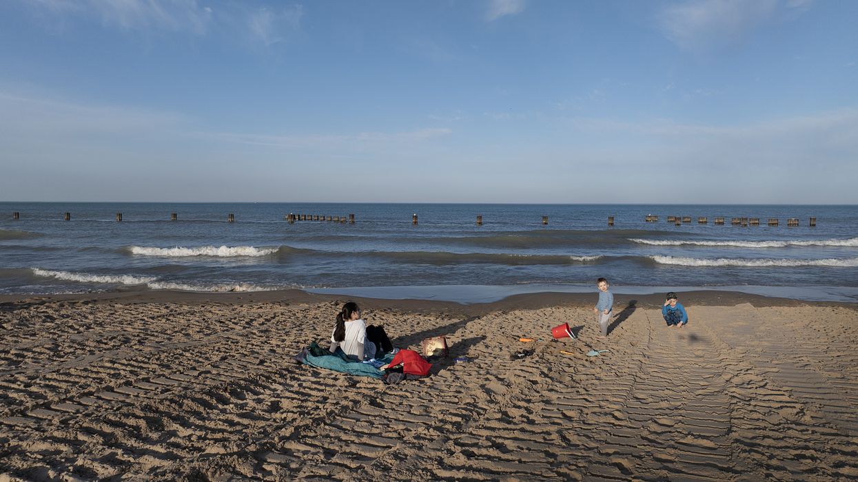 People sit on the beach along Lake Michigan on February 26, 2024 in Chicago, Illinois.