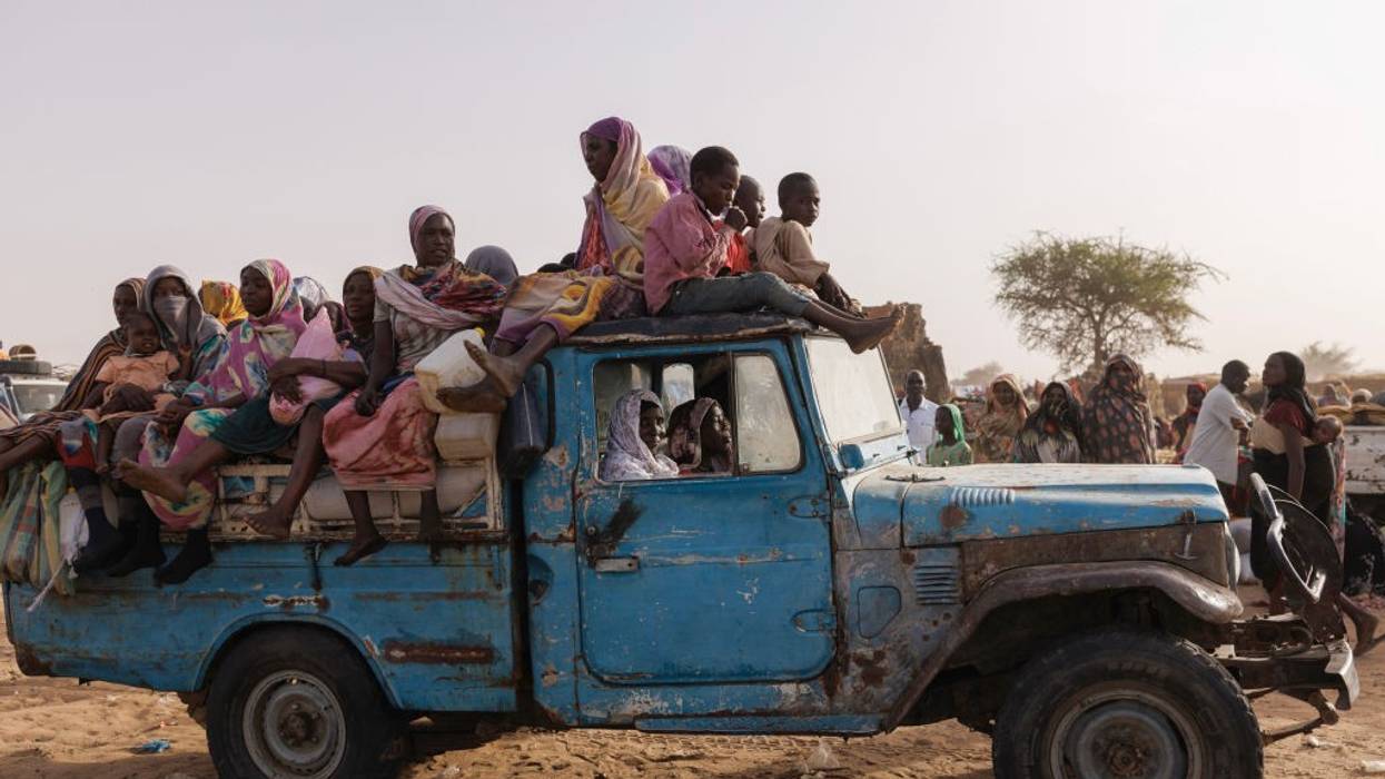 people sitting in and on top of an old truck