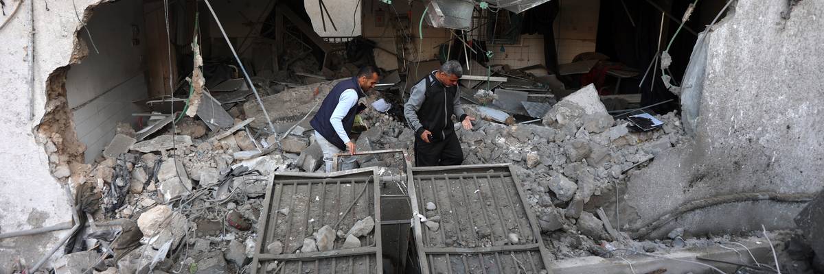 People sort through rubble of hospital in Gaza.