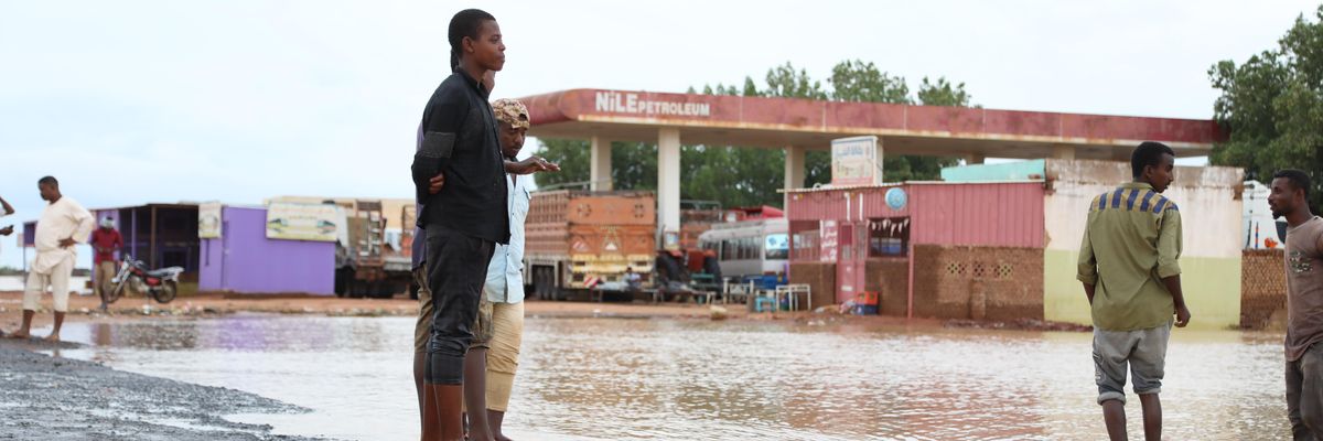People stand on a damaged road after deadly flooding in Al Jazirah, Sudan on August 20, 2022.