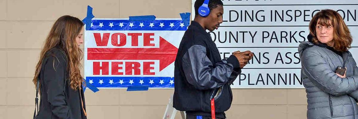 People stand on line waiting to vote.