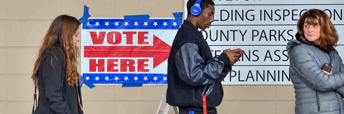 People stand on line waiting to vote.